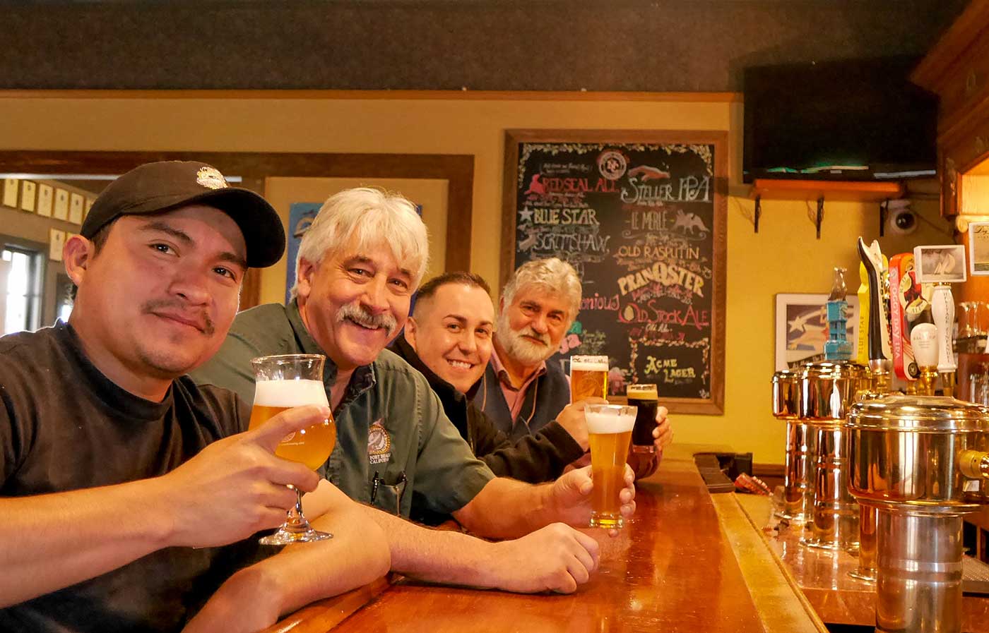 Picture of Samuel Blanco, Chuck Martins, Obed Salazar, and Mark Ruedrich holding glases of north coast beer.