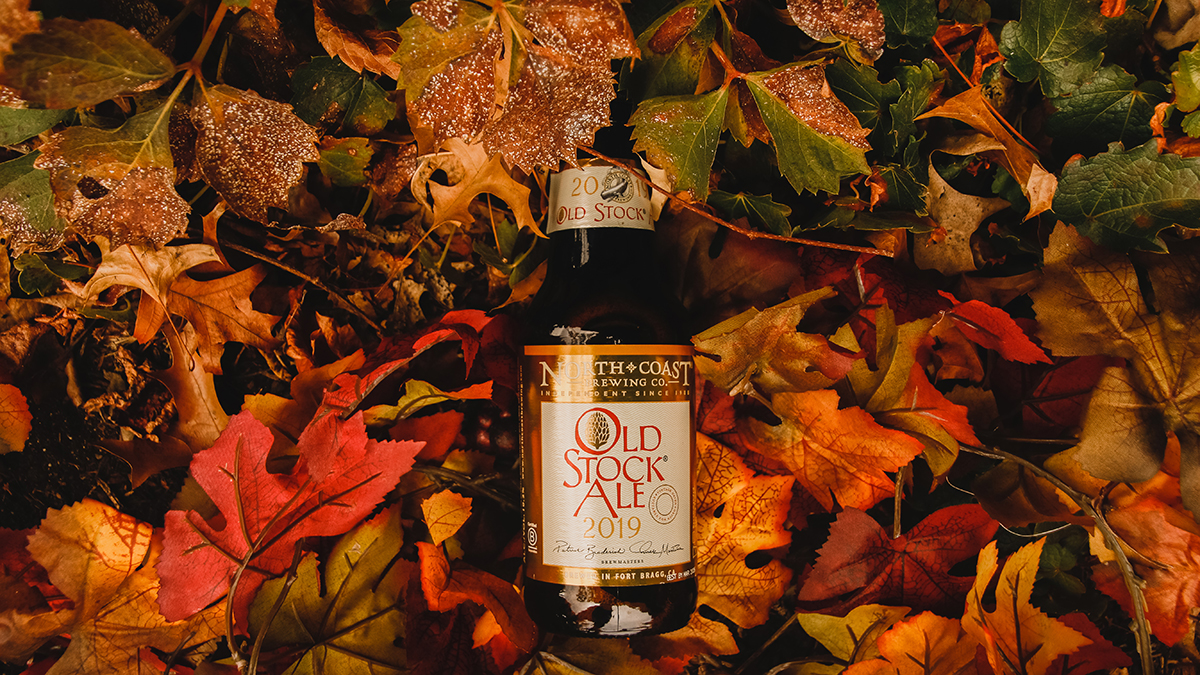 A bottle of Old Stock Ale laying in fall leaves.