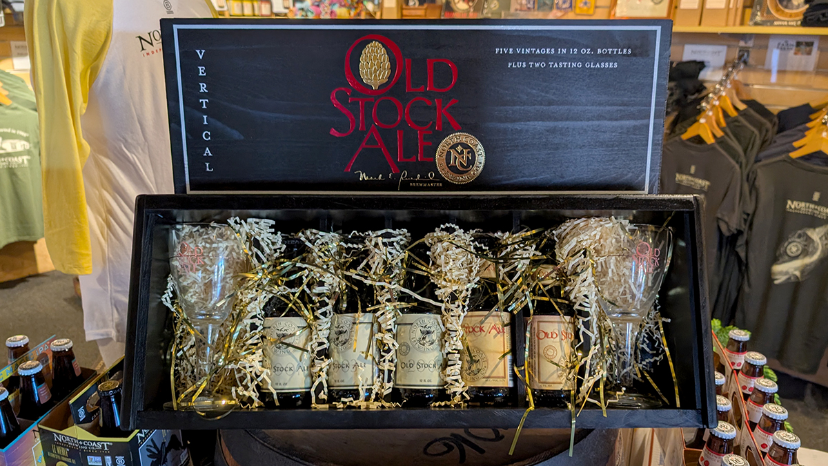 A gift box with confetti, two glasses, and five aged bottles of Old Stock Ale from different vintages.