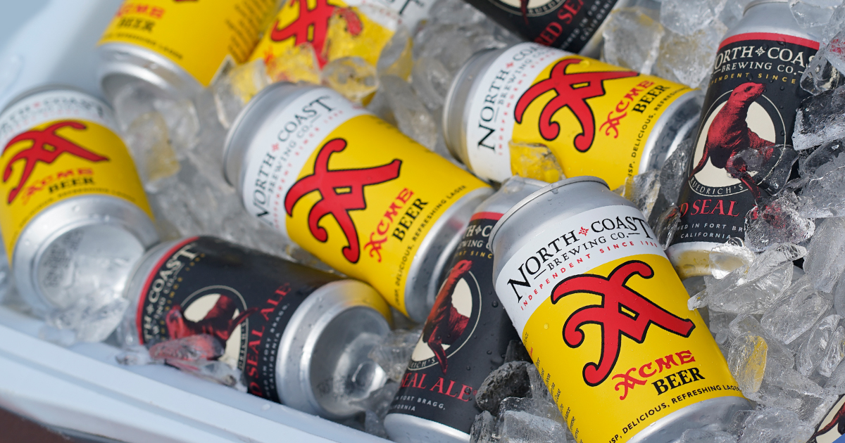 Cans of Acme Beer and Red Seal Ale in an ice chest with ice.
