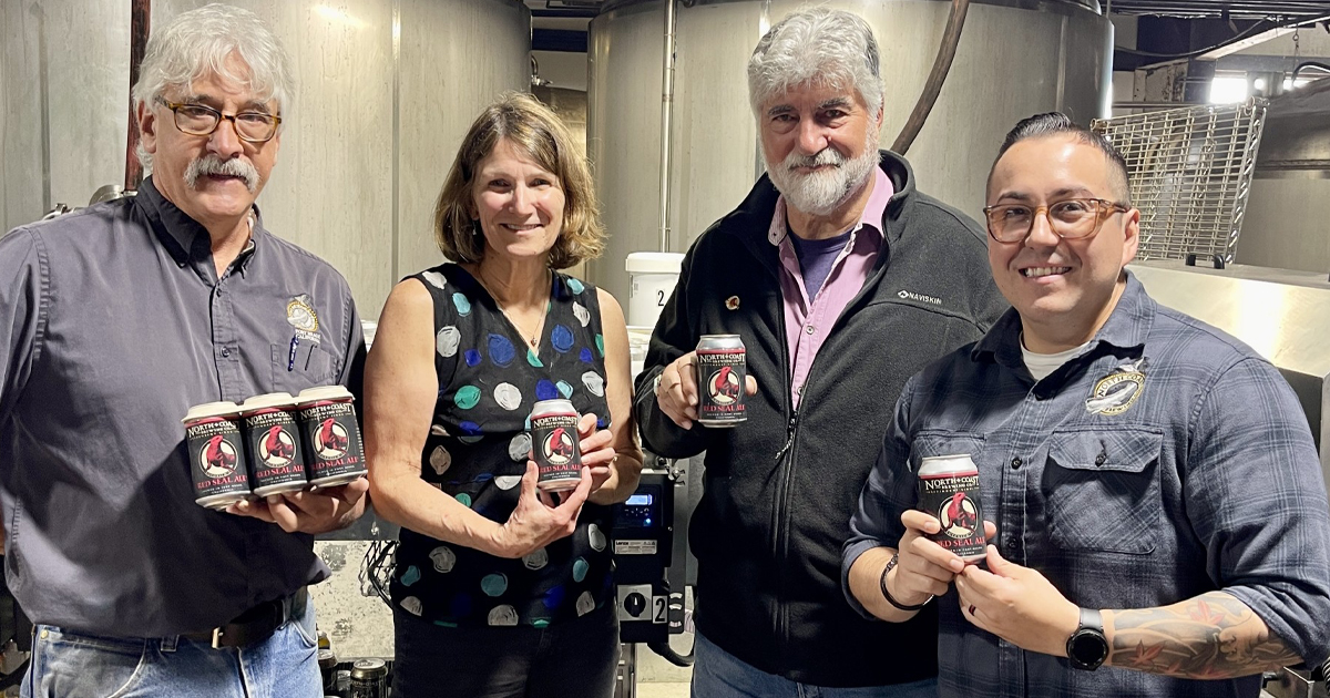 North Coast Brewing Co. Brewmaster, CEO, Founder, and Assistant Brewmaster holding cans of Red Seal Ale at the first canning run.